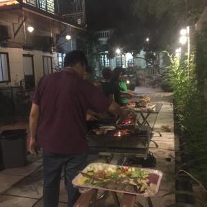 a man cooking food on a grill at night at Tam Coc Craft Homestay in Ninh Binh