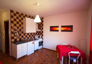 eine kleine Küche mit einem Tisch und einem roten Tischtuch in der Unterkunft [Ospedale] Casa DeMedicis in Novara