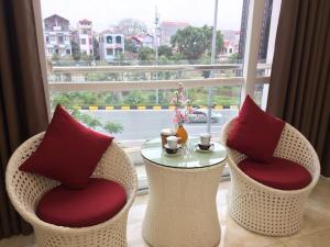 HD House في Noi Bai: كرسيين وطاولة أمام النافذة