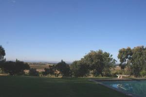 un campo de golf con una piscina de agua y árboles en Casa Rural El Rivero en Jaraiz de la Vera