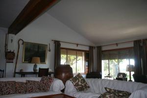 una sala de estar con 2 sofás blancos y ventanas en Casa Rural El Rivero, en Jaraíz de la Vera