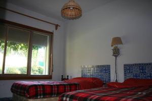 a bedroom with two beds and a window at Casa Rural El Rivero in Jaraiz de la Vera +5 photos