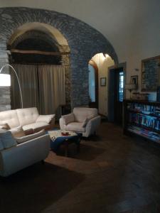 een woonkamer met 2 banken en een stenen muur bij Giunasco in Bagnone