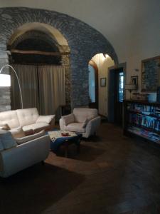 a living room with two couches and a stone wall at Giunasco in Bagnone