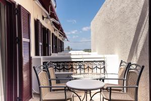 d'une terrasse avec des chaises et des tables sur un balcon. dans l'établissement Agistri Hotel, à Skala