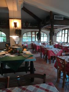 een restaurant met tafels en stoelen met rode tafellakens bij Giunasco in Bagnone