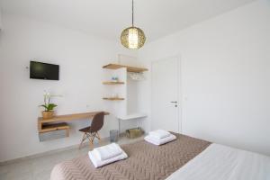 a bedroom with a bed and a desk and a chair at The Wave in Sidari