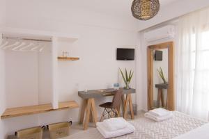 a white room with a desk and a table at The Wave in Sidari