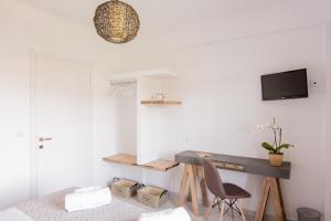 a white room with a desk and a chair at The Wave in Sidari