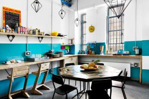 a kitchen with a table with a bowl of fruit on it at Madama Hostel & Bistrot in Milan