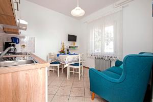 a kitchen with a blue couch and a table at Apartments Relax in Rovinj