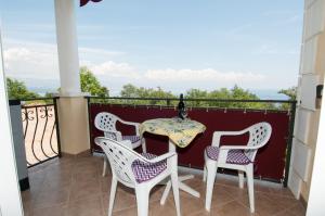 patio ze stołem i krzesłami na balkonie w obiekcie Dragica w mieście Lovran