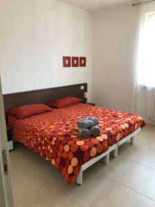 - une chambre avec un lit avec un animal rembourré dans l'établissement appartamenti vespucci 16, à Bardolino
