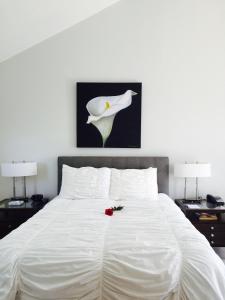 a white bed with a flower on top of it at The Drake Inn in Hampton Bays