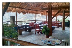 a restaurant with tables and chairs in a pavilion at La Tortuga Hostel in Taganga