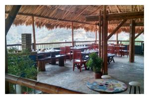 a restaurant with tables and chairs in a pavilion at La Tortuga Hostel in Taganga