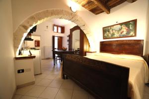 1 Schlafzimmer mit einem großen Bett und einer Küche in der Unterkunft Case Vacanza Al Borgo Antico in Vico del Gargano