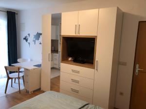 a bedroom with a large white cabinet with a tv at Jakov Apartments in Orebić