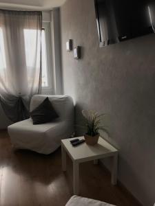 sala de estar con silla blanca y mesa en Residence Campanelle 54, en Trieste