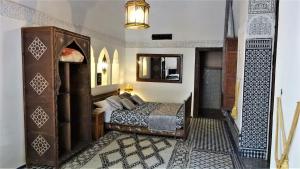 a bedroom with a bed and a mirror at Riad Razane Fez in Fès
