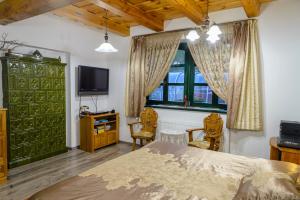 a bedroom with a bed and a tv and a window at Tündérgyöngye Apartmanház in Zirc