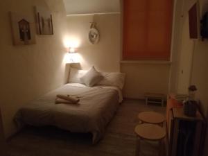 Casa Mirka في سانريمو: غرفة نوم صغيرة مع سرير وشمعة عليه