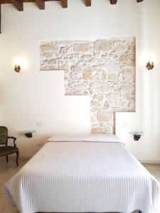 a bedroom with a bed and a stone wall at Buonanotte Margherita in Taranto