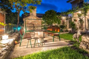 a table and two chairs and a bench in a yard at Apartman Verica in Trogir
