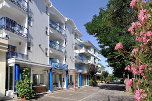un edificio bianco con balconi blu su una strada di Hotel Amedeo a Misano Adriatico