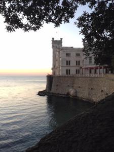 un edificio blanco en el borde del agua en Residence Campanelle 54, en Trieste
