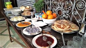 stół z talerzami i miskami z jedzeniem w obiekcie Riad Razane Fez w Fezie