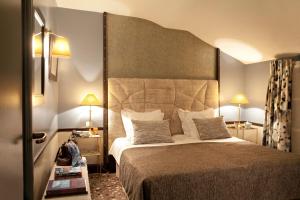 a hotel room with a bed with a large headboard at H&ocirc;tel Th&eacute;r&egrave;se in Paris