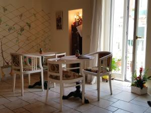 two white tables and chairs in a room with a window at Buonanotte Margherita in Taranto