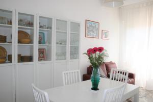 a table with a vase with red flowers on it at A Casa di Tilde in Polignano a Mare