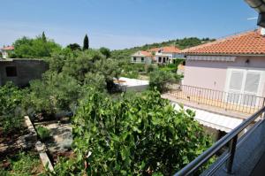 a view of a garden with bushes and a house at Slanica studio ID 816 by HeartofDalmatia in Murter