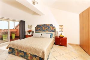 a bedroom with a bed with a blue headboard at Taormina center 4 BR penthouse, terrace with views in Taormina