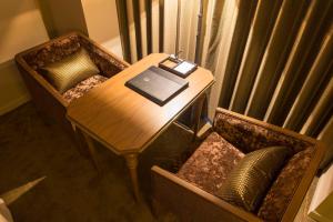 a table and chair with a laptop and a book on it at Royal Park Hotel Takamatsu in Takamatsu