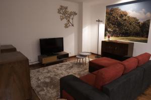 a living room with a couch and a flat screen tv at Happily Ever Lisbon in Lisbon
