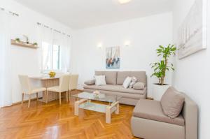 ein Wohnzimmer mit Sofa und Tisch in der Unterkunft Apartment ''Pomalo'' in Split