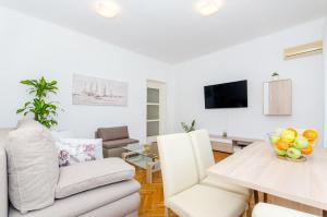ein Wohnzimmer mit Sofa und Tisch in der Unterkunft Apartment ''Pomalo'' in Split