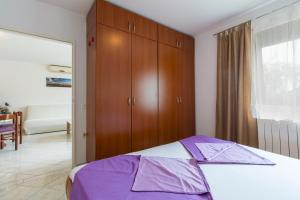 a bedroom with a bed and a wooden cabinet at Apartman Studio in Pula
