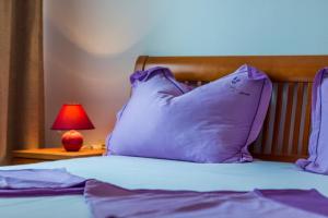 a bed with a pillow and a lamp on a table at Apartman Studio in Pula