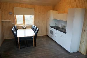 a small kitchen with a table and chairs at Middalskot Cottages in Laugarvatn