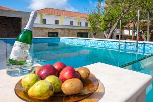 einen Obstteller auf einem Tisch neben einem Pool in der Unterkunft PRIVATE Sapphiros Villa in Kissamos