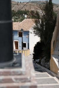 a street with blue and white buildings on a hill at Cehegin Old Town House in Cehegín