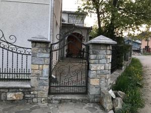 a gate to a house with a stone fence at Guest House Perlyna in Verkhovyna