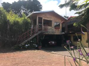 a house with a staircase leading to a balcony at Hotel Chalets Los Volcanes in Alajuela City