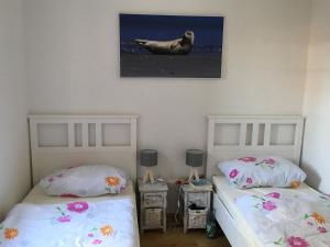 ドルヌマージールにあるFerienhaus Menkhoffのベッドルーム1室(ベッド2台付)が備わります。壁に絵が描かれています。