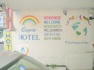 a wall with a rainbow and some signs on it at Hotel Capric in Viña del Mar