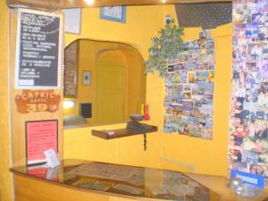 un restaurante con barra y pared amarilla en Hotel Capric, en Viña del Mar